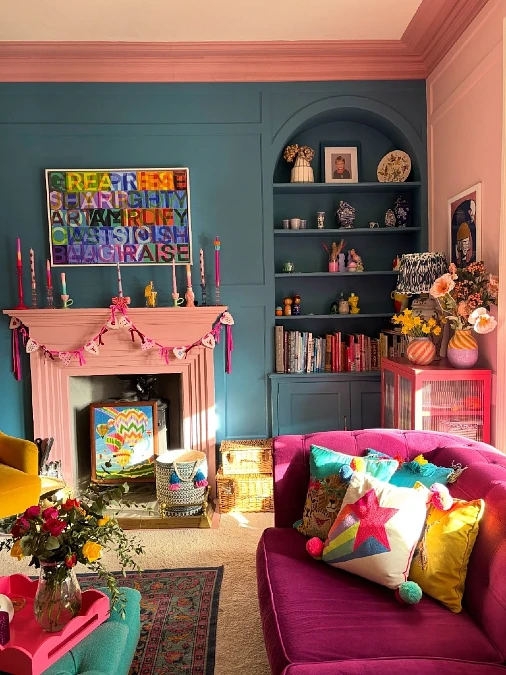 Teal Paneled Wall with Built-In Arch Bookshelf and Pink Fireplace