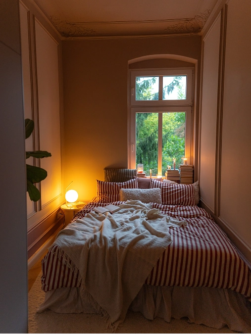 Floral Window Bedroom with Layered Cotton Bedding and Warm Lamp Glow