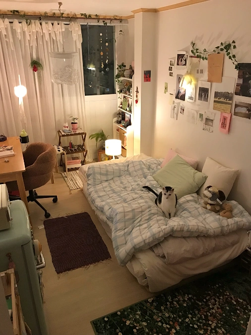 Soft Ambient Studio Bed with Collage Wall and Warm Desk Lighting