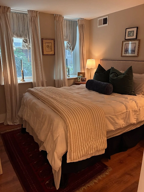 Warm Bedside Lamp with Tall Draped Windows