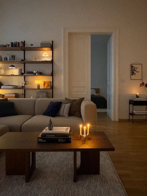 Candlelit Coffee Table with Shelf Lamps Behind the Sofa