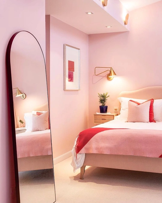 Blush Pink Bedroom Walls with Brass Sconces
