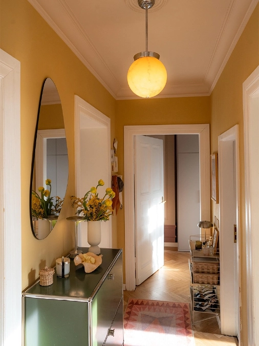 Ochre Yellow Hallway with White Trim and Globe Pendant