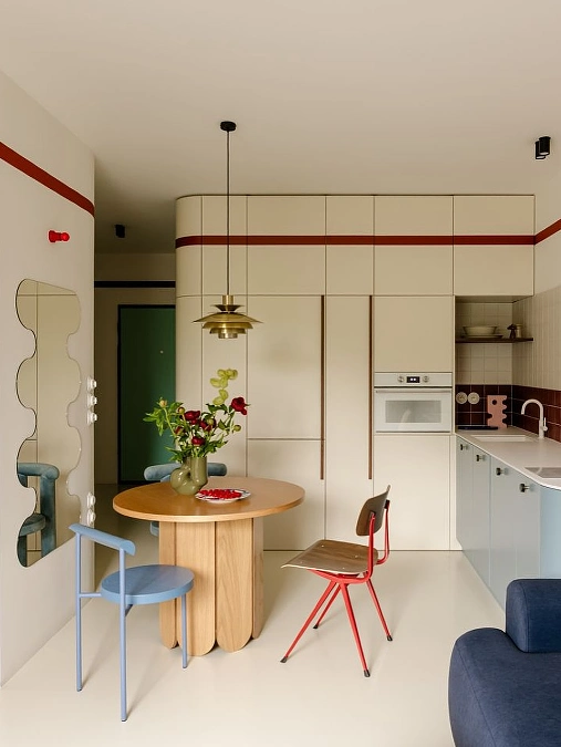 Cream Studio Kitchen with Red Accent Stripe and Blue Lower Cabinets